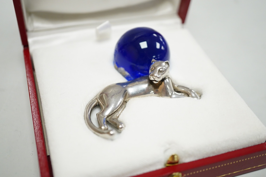 A recent Cartier paperweight, modelled as a recumbent 925 panther with blue glass sphere(a.f.), signed, in original fitted Cartier box, 56mm by 60mm.